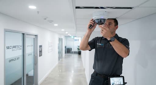 Modern dome CCTV camera mounted on a clean white ceiling